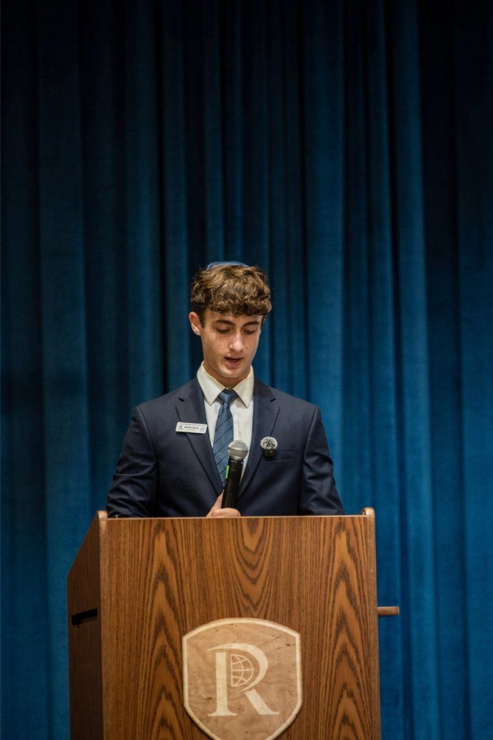 A club leader opening the evening at the podium