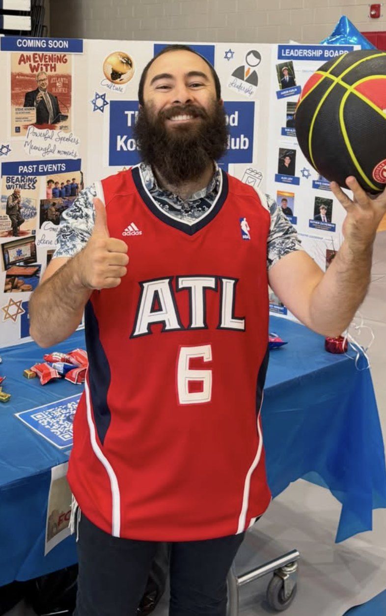 Rabbi David Goldschmidt in an Atlanta Hawks jersey at the Kosher Food Club table